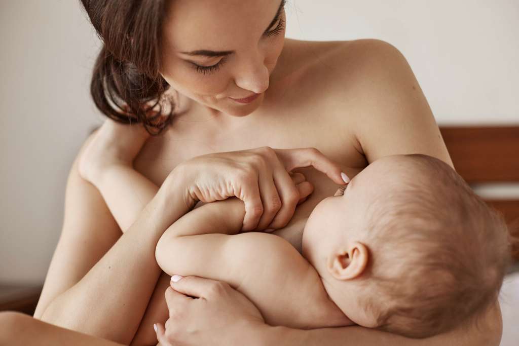 Mãe segurando bebê no colo e fazendo carinho