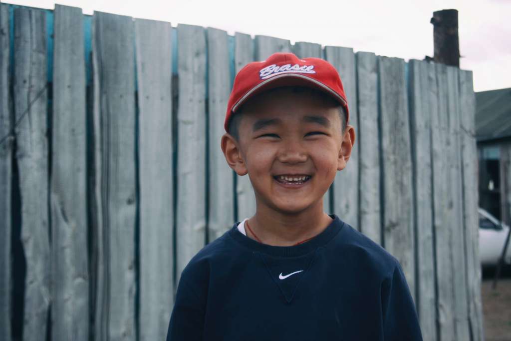 menino japonês sorrindo e posando para uma foto. 