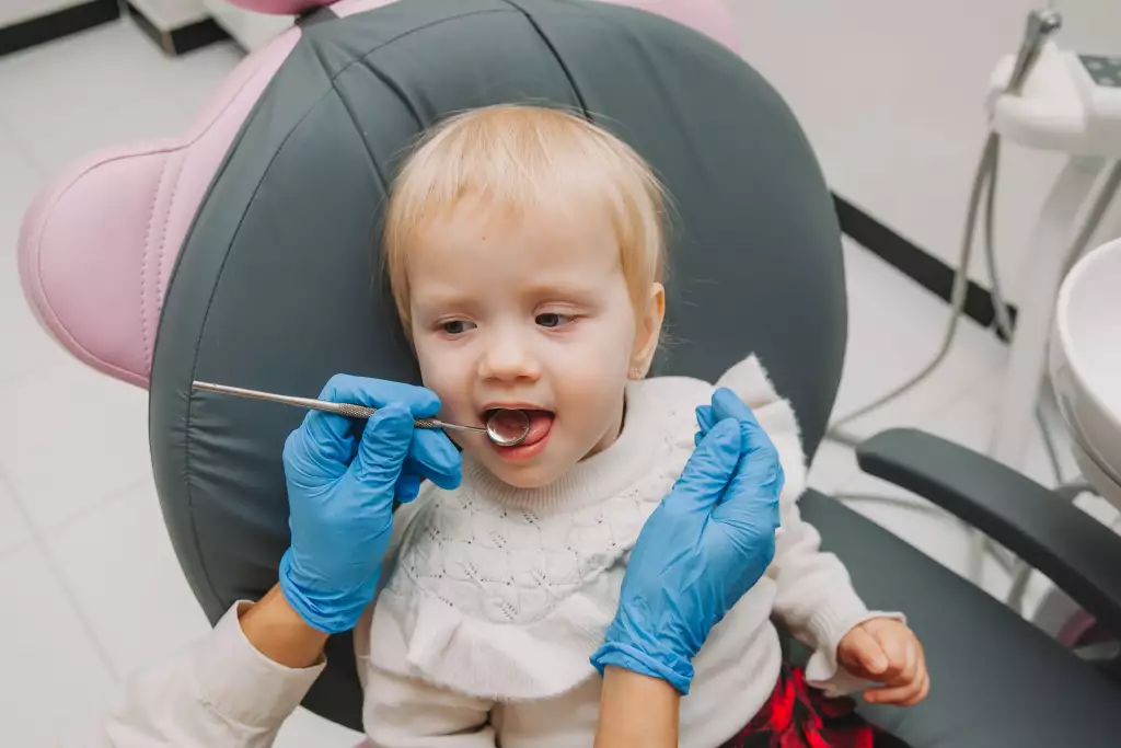 Bebê sendo atendido por um odontopediatra para avaliação da dentição tardia.